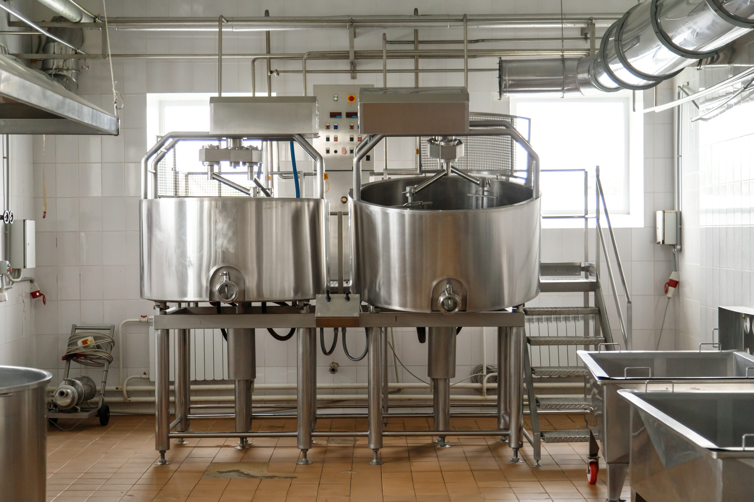 Dairy cheese factory interior with industrial appliances. Milk pasteurization, tank, bath and pipes. No people