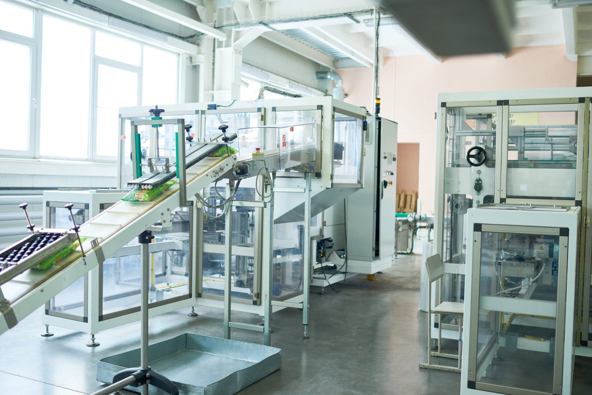 Interior of production workshop at food factory, modern assembly line units for packaging, copy space