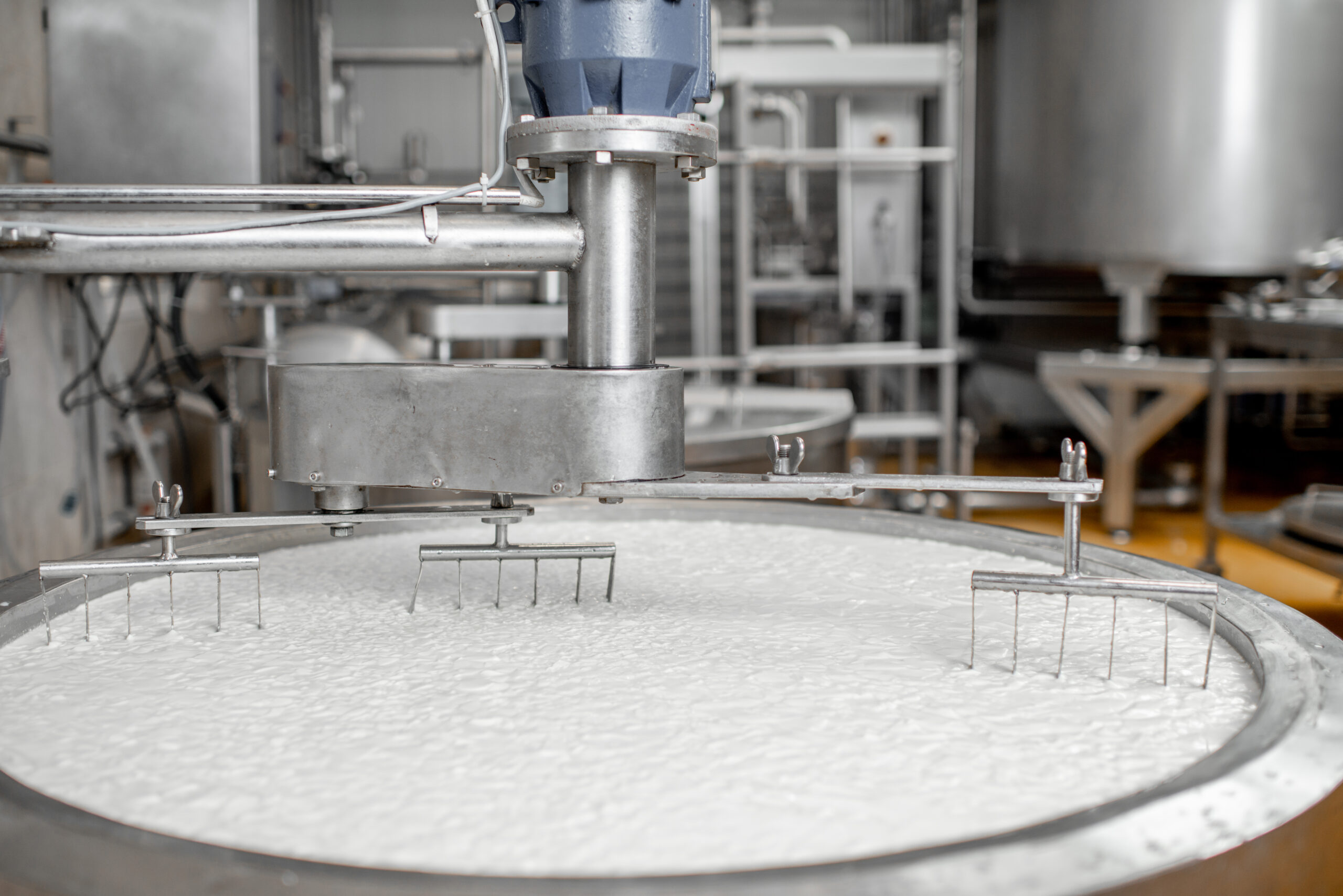 Milk mixing in the stainless tank during the fermentation process at the cheese manufacturing